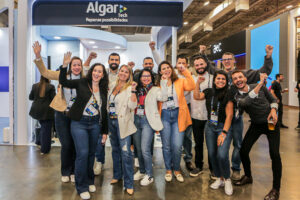 Registro do evento Conarec 2022. Várias pessoas em posição de comemoração com as mãos pra cima. Ao fundo, o stand da Algar Tech.